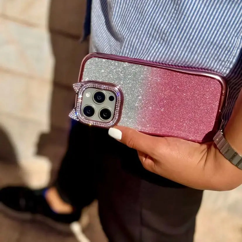 Person holding a glittery phone case with a cat design.