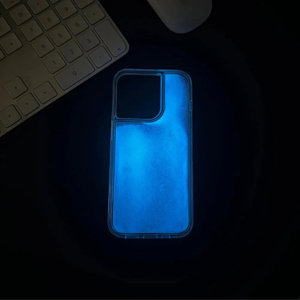 Phone case glowing blue on a dark surface with a keyboard in the background